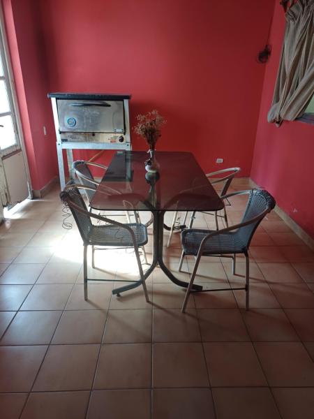 una mesa y sillas en una habitación con una pared roja en Lo de ines en Salta