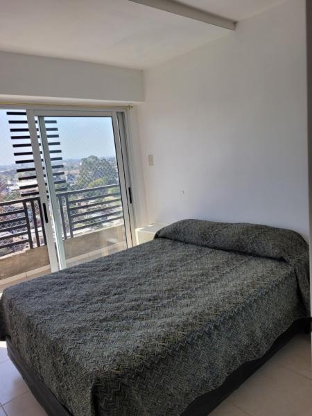 1 dormitorio con cama y ventana grande en Departamento Calle Cordoba en San Miguel de Tucumán