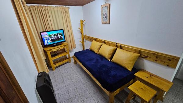 Habitación pequeña con sofá y TV. en Valhalla Casita centrica en San Martín de los Andes