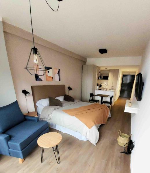 1 dormitorio con 1 cama y 1 sofá azul en Complejo premium en San Telmo, seguridad 24hs, SPA, Gym, parrrilla, coworking, rooftop en Buenos Aires