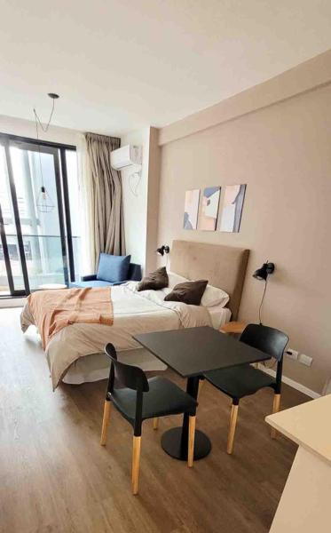 Un dormitorio con una cama y una mesa. en Complejo premium en San Telmo, seguridad 24hs, SPA, Gym, parrrilla, coworking, rooftop en Buenos Aires