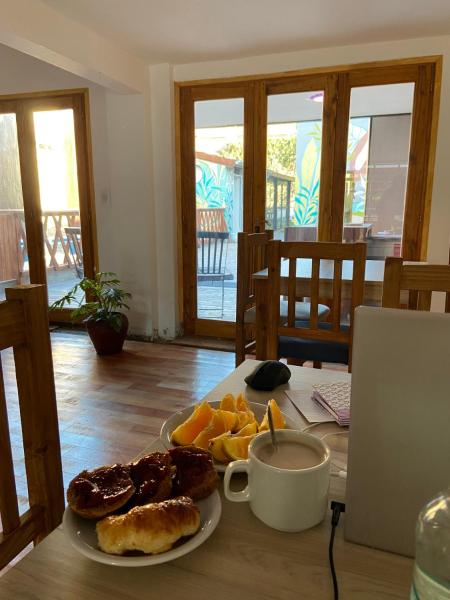 una mesa con un plato de comida y un plato de fruta en Bitelyus Hostel Club en Mar del Plata