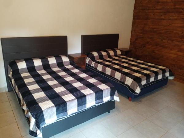 dos camas sentadas una al lado de la otra en una habitación en Quinta Don Adolfo en Puerto Iguazú