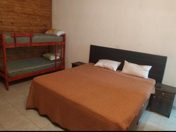 1 dormitorio con 1 cama con 2 almohadas y 1 silla en Quinta Don Adolfo en Puerto Iguazú