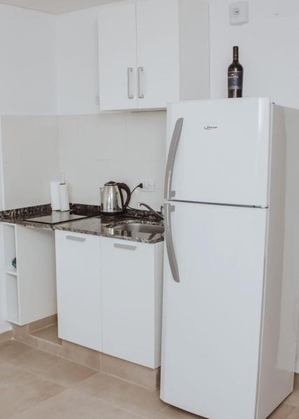 cocina blanca con refrigerador y fregadero en Yellow en San Miguel de Tucumán