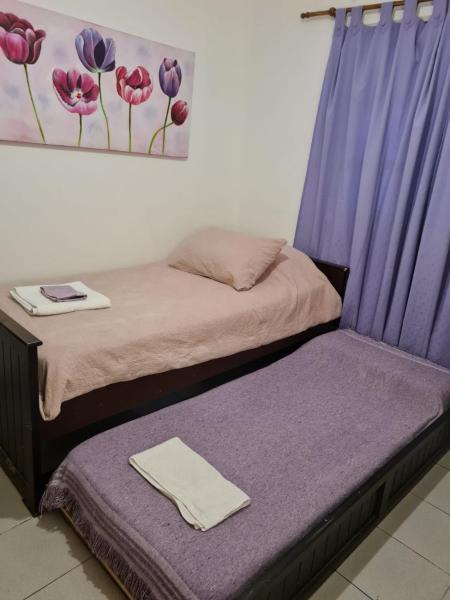 2 camas en una habitación con cortinas moradas en Casa cómoda y linda a 20min del centro. en Salta