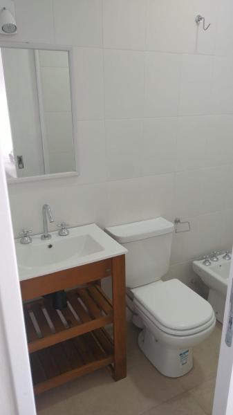 Baño blanco con aseo y lavamanos en Monoambiente centrico en Gualeguaychú