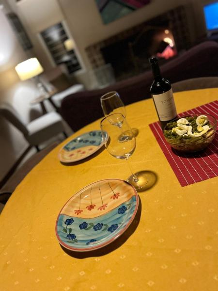una mesa amarilla con dos copas y una botella de vino en Nuestro hogar en Villa General Belgrano