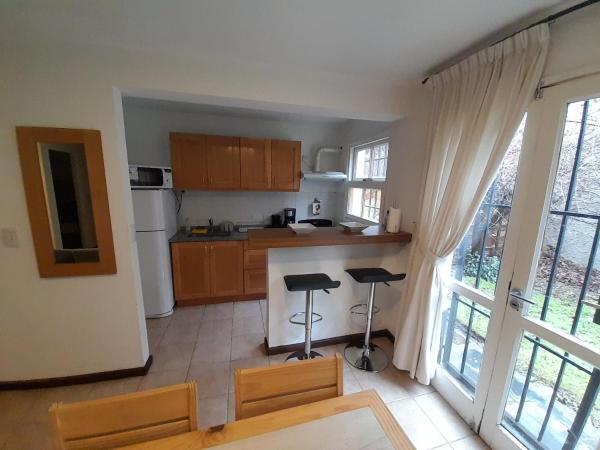 una cocina con una mesa y dos taburetes. en Departamento centrico - 4 personas en San Martín de los Andes