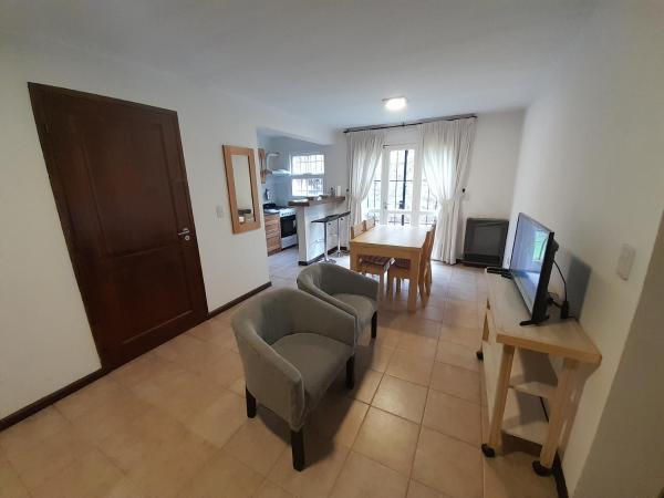 sala de estar con mesa, sillas y TV en Departamento centrico - 4 personas en San Martín de los Andes