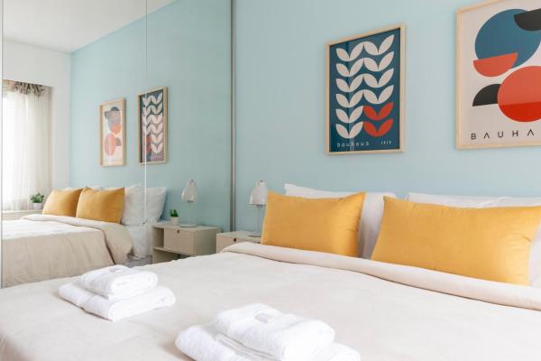 2 camas en un dormitorio con paredes amarillas y azules en Bulnes 1500 - 1 Bd Pool In Palermo Viejo en Buenos Aires