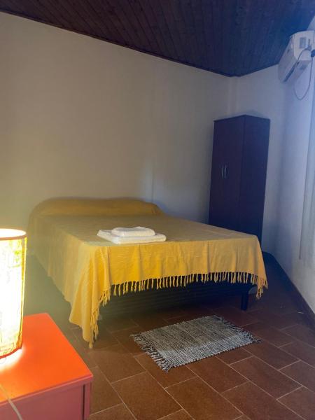 Una cama en una habitación con una manta amarilla. en Dpto Céntrico con Balcón en Puerto Iguazú