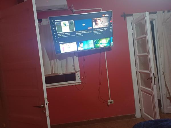 una pantalla de proyección en una habitación con una pared roja en Lo de ines en Salta