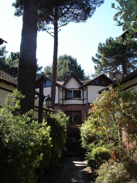 una casa con árboles y arbustos delante de ella en Pinamar De La Lisa en Pinamar