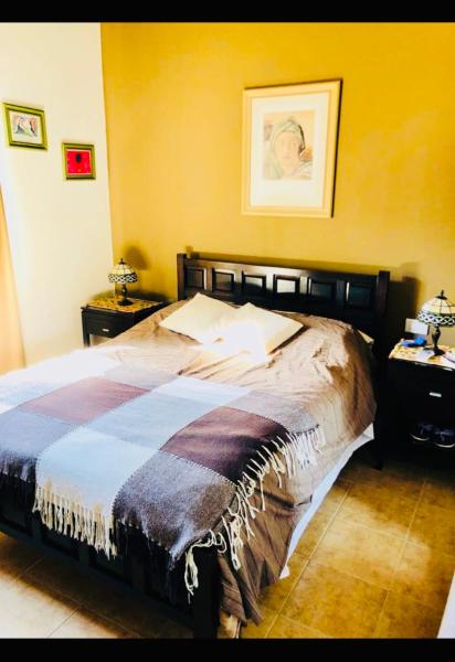1 dormitorio con 1 cama y una foto en la pared en Villa emma en Villa General Belgrano