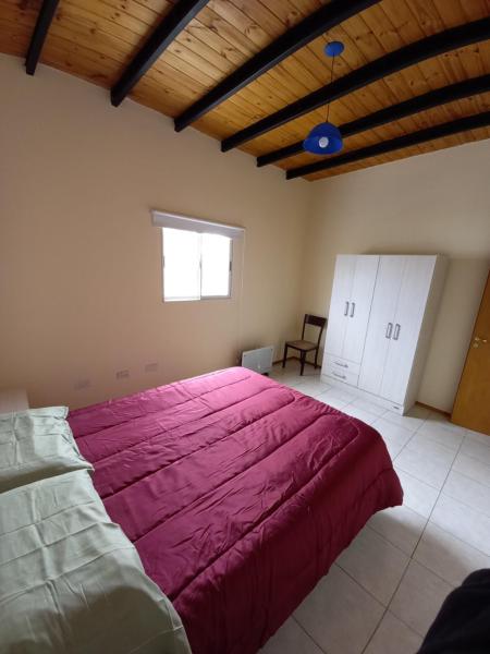 1 dormitorio con 1 cama grande con manta rosa en DEPARTAMENTOS CORDOBA 1590 en San Juan