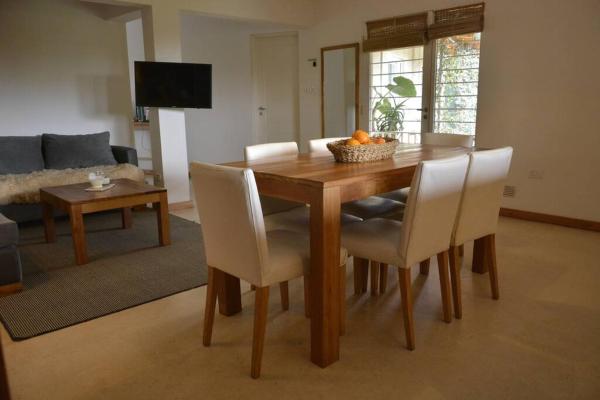 En la sala de estar hay una mesa de comedor de madera con sillas blancas. en se mejora precio ver en Anfitrion en Gualeguaychú