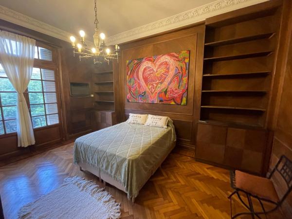 1 dormitorio con 1 cama y una pintura en la pared en Estudio Live en Buenos Aires