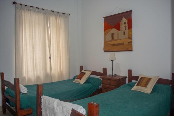 Habitación con 2 camas individuales y ventana. en Deptos Bajo la Viña en San Salvador de Jujuy