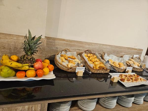 buffet con fruta y cestas de pan y bollería en DAKAR HOSTEL en Mendoza