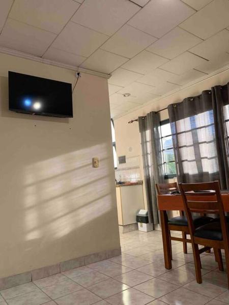 Habitación con 2 sillas y TV en la pared en Departamento Micro-centro Salta en Salta