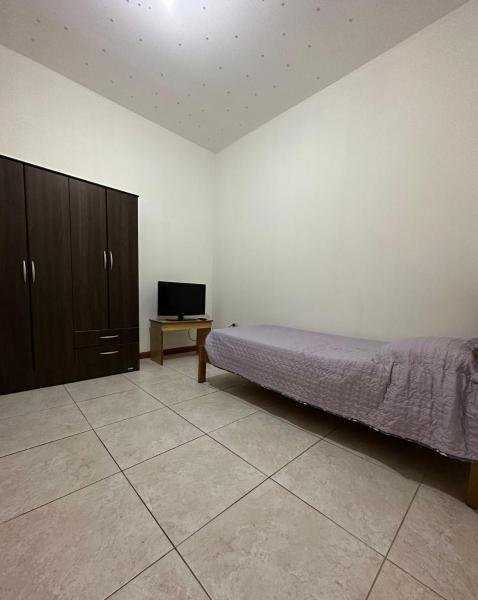 1 dormitorio con 1 cama y TV. en Dpto en el corazon de Mendoza en Mendoza