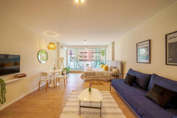 sala de estar con sofá azul y mesa en Fliphaus Be Libertador - Lux 3 Pax Loft 10-3 en Buenos Aires