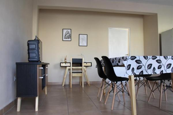 sala de estar con sillas, mesa y TV en Chañares Centric Apartment en Mendoza