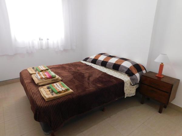 Un dormitorio con una cama con dos bandejas. en Las Rosas 2 en Salta