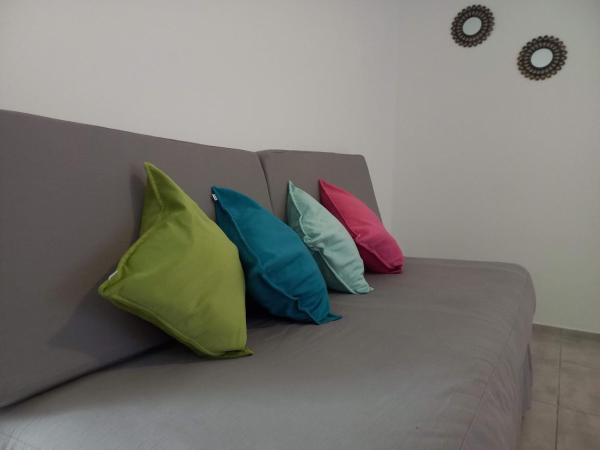 tres almohadas coloridas sentadas en un sofá gris en La Gema apartamento en Mendoza