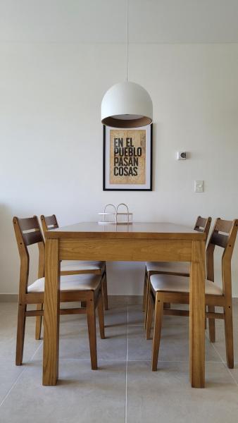 mesa de comedor con sillas y una foto en la pared en Cuatro Vientos en Puerto Madryn