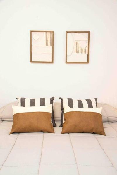 Habitación blanca con 2 almohadas y 2 cuadros en la pared en Casa Huesped V Ubicadísimo, pocos metros de la peatonal, parking privado gratis! en Mendoza