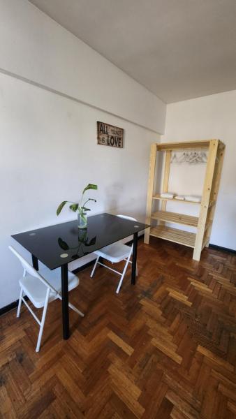 un comedor con una mesa negra y una silla en Greta Apartment II en Mendoza