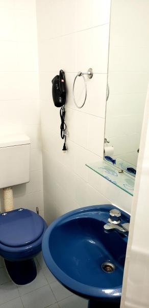 baño con lavabo azul y teléfono en Amar el mar en Puerto Madryn