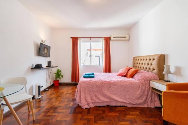 1 dormitorio con cama, mesa y ventana en Disfruta Recoleta desde este tranquilo Monoambiente en Buenos Aires