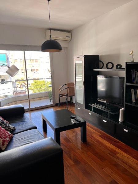 sala de estar con sofá y TV en Best location, comfort and luminous in Palermo 1 en Buenos Aires