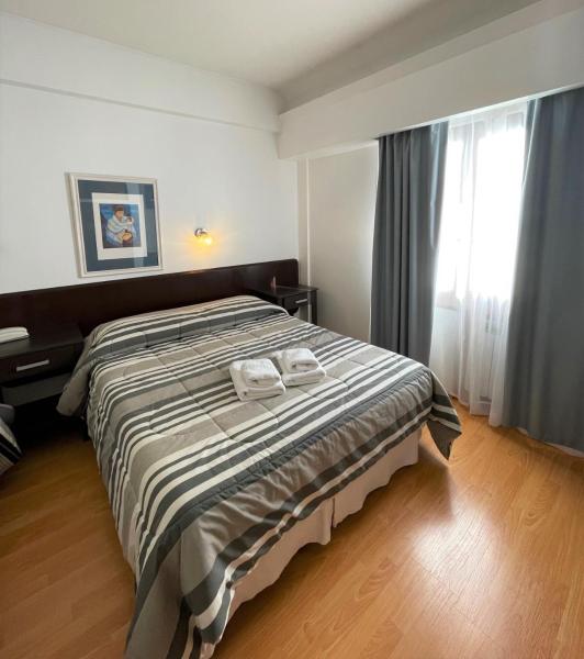 1 dormitorio con 1 cama con 2 toallas en Rosa de los Viajes en San Martín de los Andes