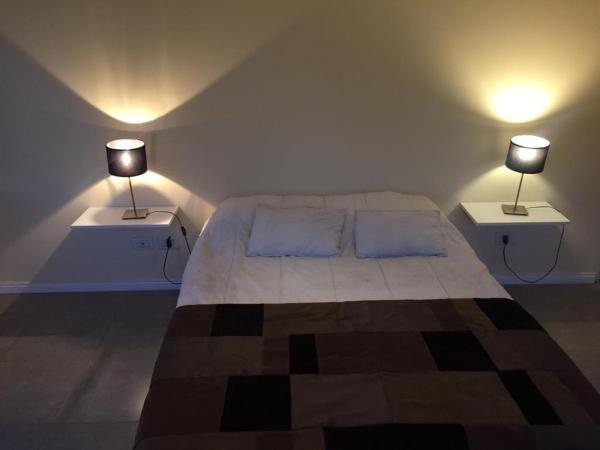 1 dormitorio con 1 cama y 2 lámparas en 2 mesas en Departamento pleno centro de Mendoza con cochera en Mendoza
