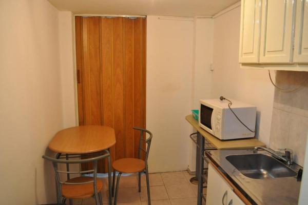 una pequeña cocina con mesa y microondas en Alojamiento en pleno centro en Mendoza