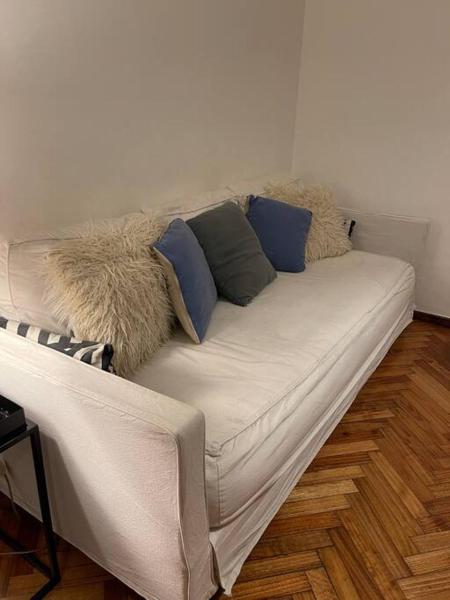 un sofá blanco con algunas almohadas encima en Excelente Departamento en Recoleta en Buenos Aires