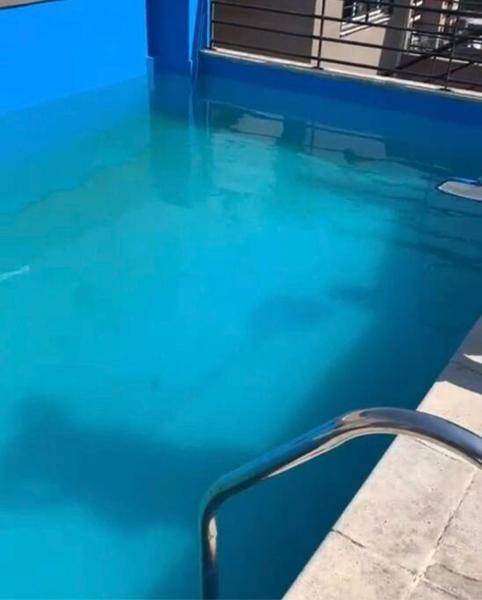 una piscina de agua azul y una barandilla metálica en “Buenos Aires Estrella”- 2 dormitorios en San Miguel de Tucumán