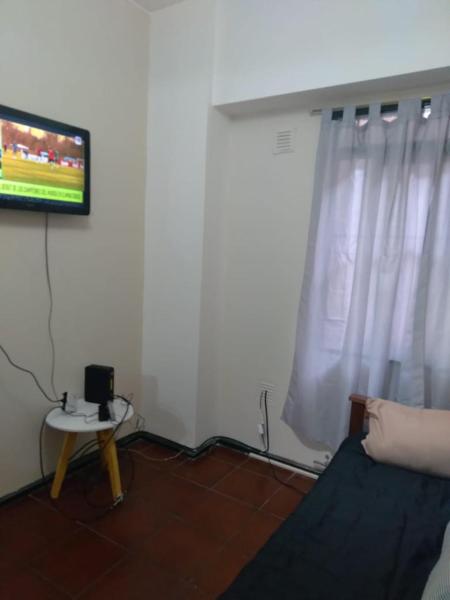 sala de estar con TV y ventana en Departamento céntrico en Mendoza