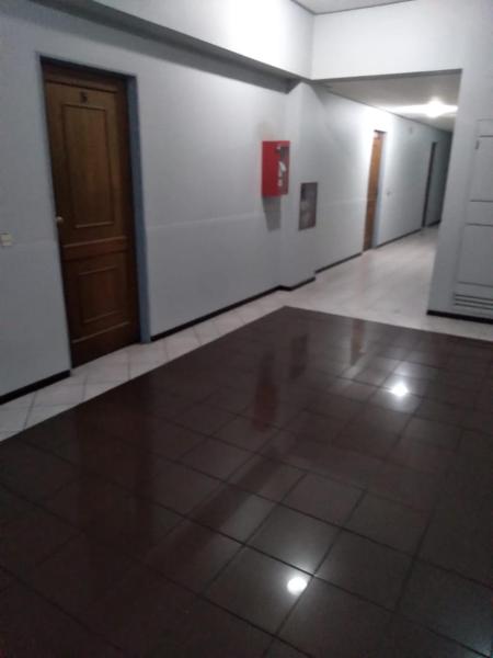 pasillo vacío con puerta y suelo de baldosa en Departamento céntrico en Mendoza