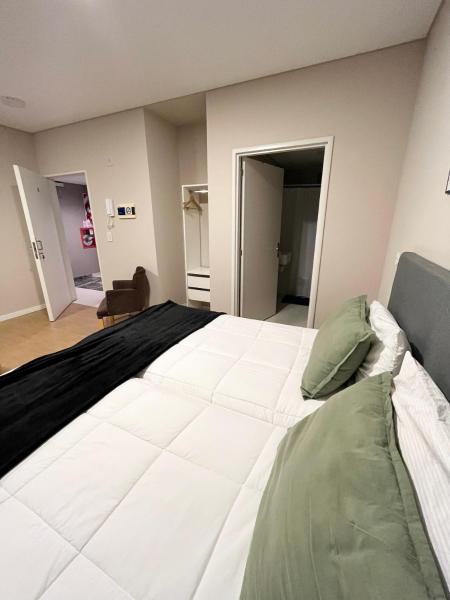 1 cama blanca grande en una habitación con una habitación que da a un baño privado. en 6A Monoambiente capital, amplio, luminoso y acogedor en Buenos Aires