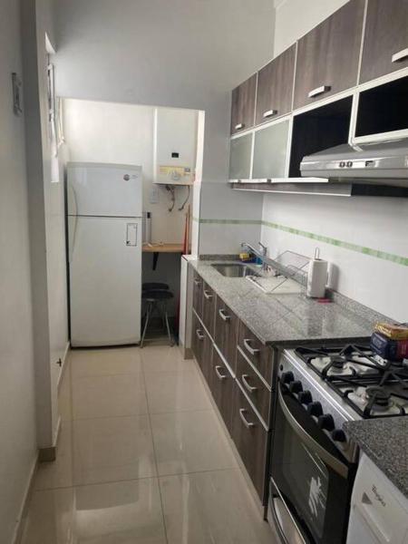 cocina con refrigerador blanca y fogones en Comodo departamento de 3 amb. en Buenos Aires