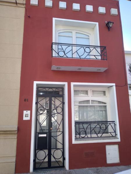 un edificio rojo con una puerta y dos ventanas en Ciclamen en Gualeguaychú