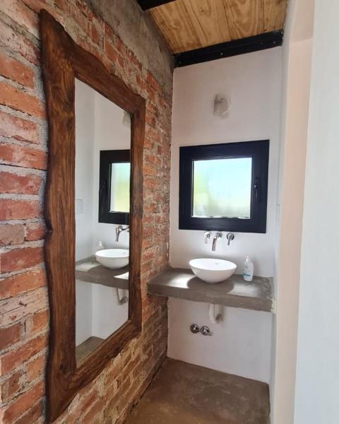 Baño con 2 lavabos y espejo en Cabaña del Cedro Azul, San Lorenzo en Salta