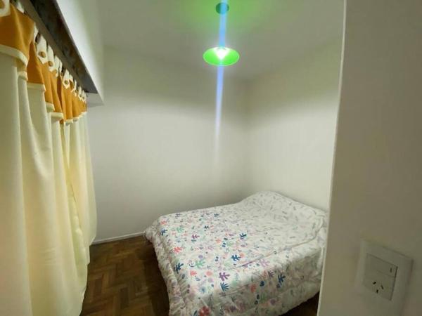 1 dormitorio con 1 cama y una luz en la pared en Alojamiento completo Duarte en Buenos Aires