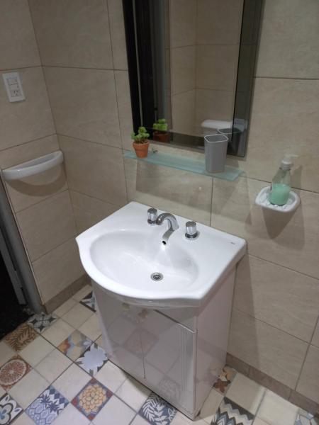 y baño con lavabo blanco y espejo. en Departamento amplio - Mendoza Centro en Mendoza