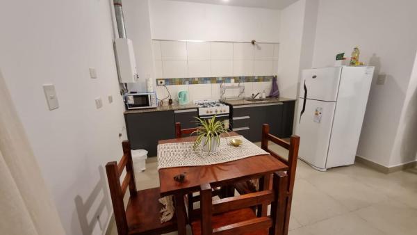 una pequeña cocina con mesa y refrigerador en Deptos Bajo la Viña en San Salvador de Jujuy